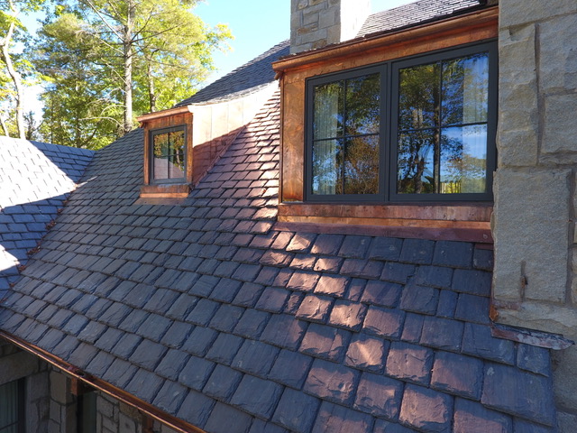 Slate roof with copper dormer flashing on a stone mountain home in Cashiers, North Carolina